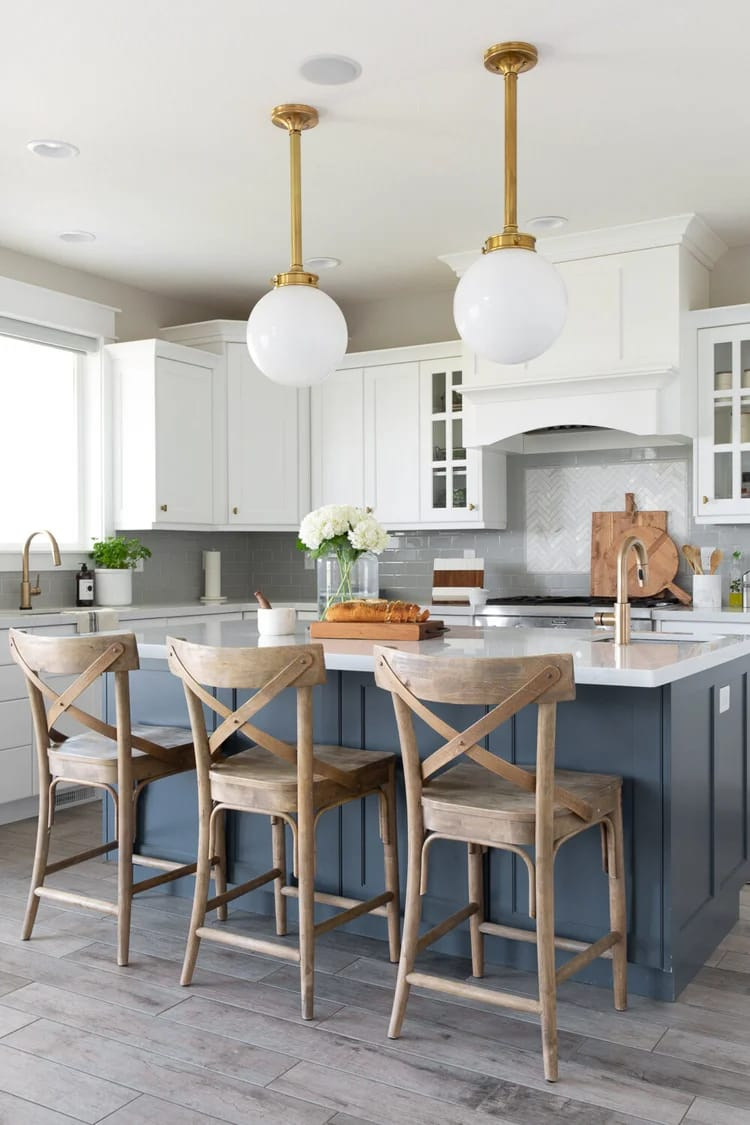 Custom kitchen with blue island and brass pendant lighting